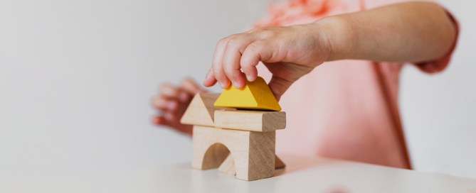 A young child builds a structure with building blocks.