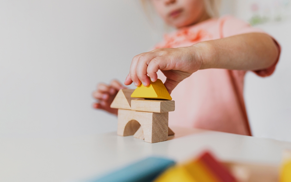 A young child builds a structure with building blocks.