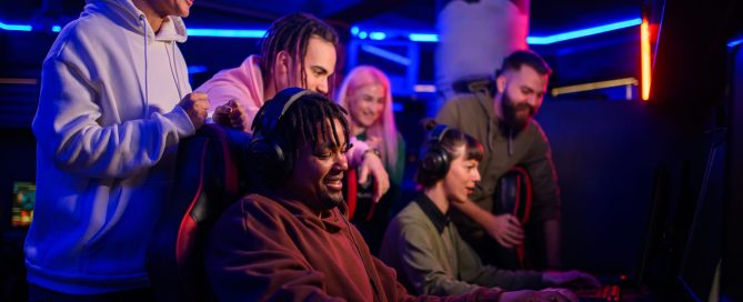 A group of young people sitting around a screen playing video games